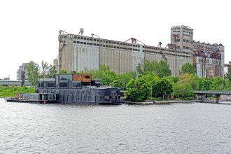Bota Bota floating spa boat moored in Montreal's Old Port, a Nordic spa in Montreal, with grain elevators behind