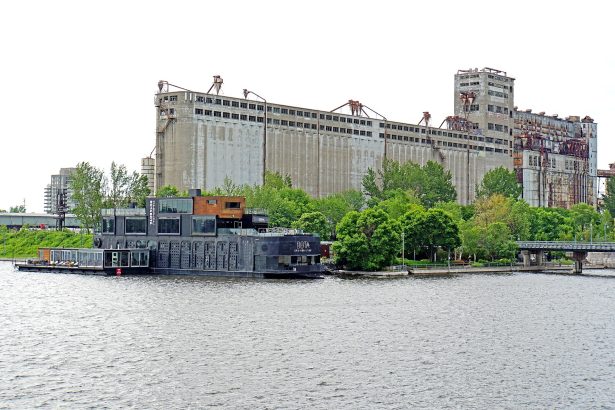 Bota Bota floating spa boat moored in Montreal's Old Port, a Nordic spa in Montreal, with grain elevators behind