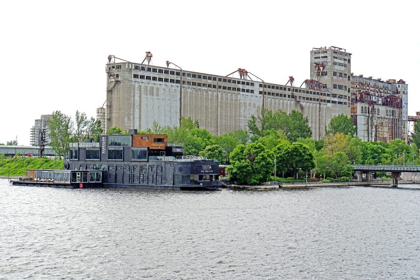Bota Bota floating spa boat moored in Montreal's Old Port, a Nordic spa in Montreal, with grain elevators behind